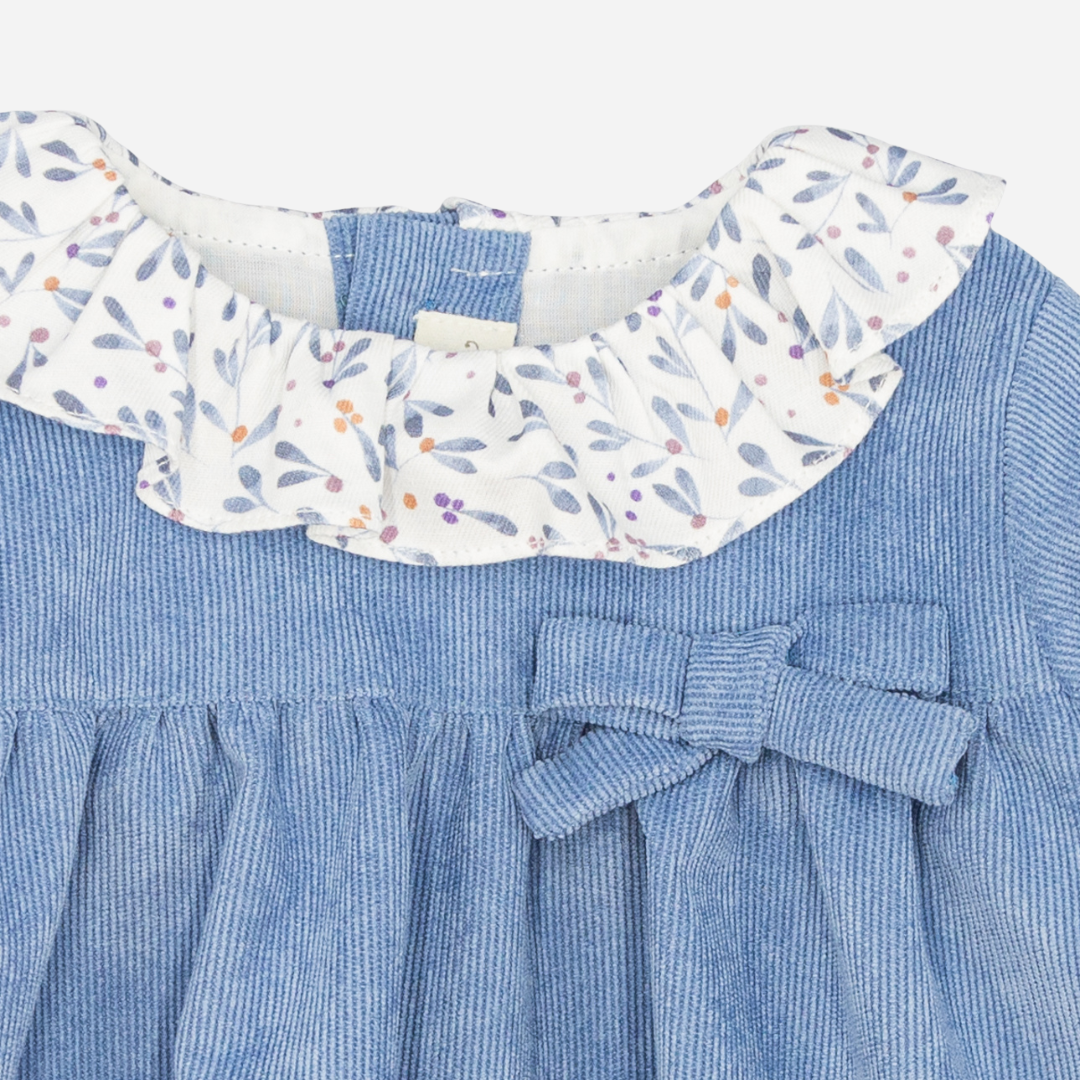 Sold at Bombon shop, designed by Fina Ejerique, a sky-blue corduroy baby dress with floral ruffle collar, bow detail, and long sleeves. zoom
