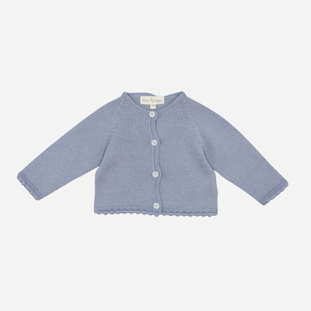 Sold at Bombon shop, designed by Fina Ejerique, a powder-blue knit baby cardigan with scalloped trim and front buttons. front