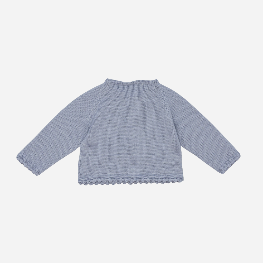 Sold at Bombon shop, designed by Fina Ejerique, a powder-blue knit baby cardigan with scalloped trim and front buttons. back