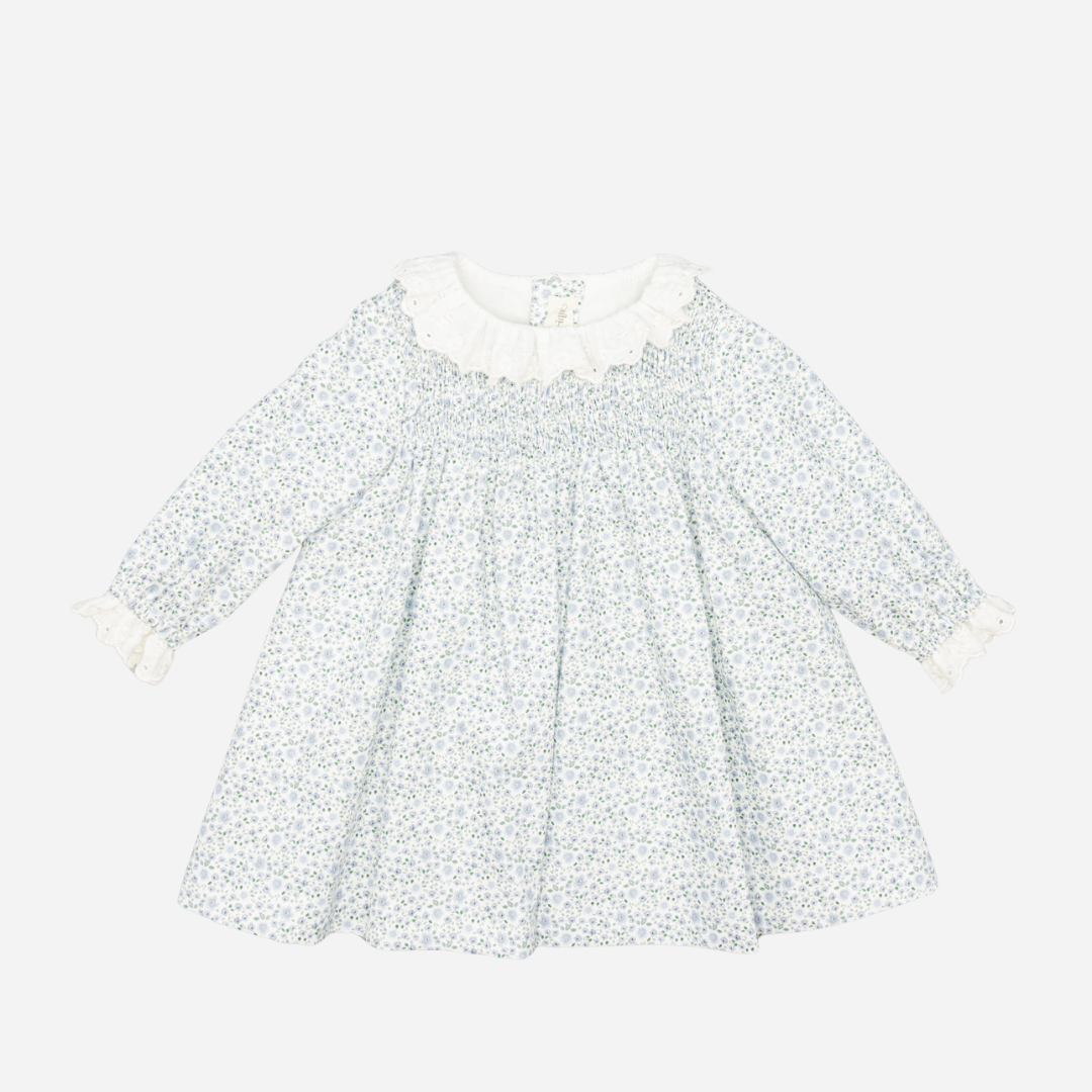 Sold at Bombon shop, designed by Fina Ejerique, a white floral viyella baby dress with smocked bodice, ruffle collar, and long sleeves. front