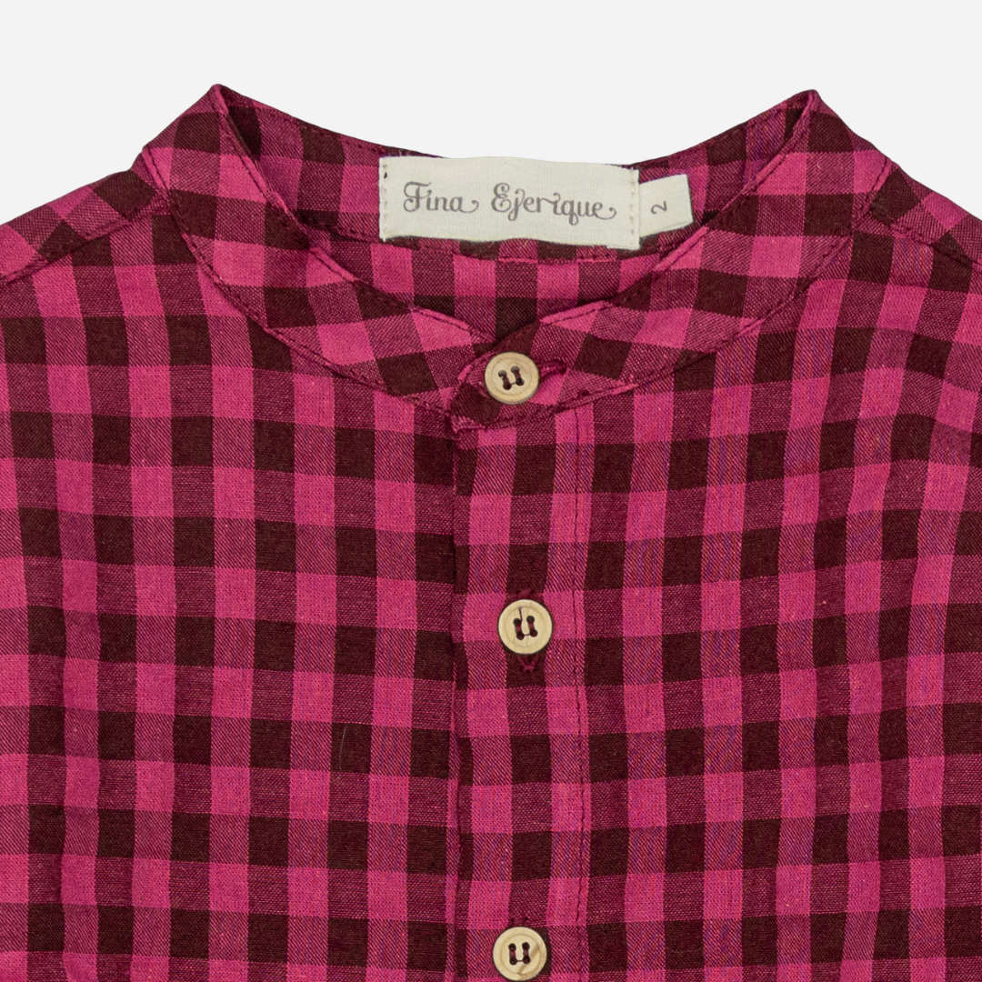 Sold at Bombon shop, designed by Fina Ejerique, a burgundy and black checkered cotton shirt with wooden buttons and long sleeves, styled to pair with the burgundy dog sweater. zoom