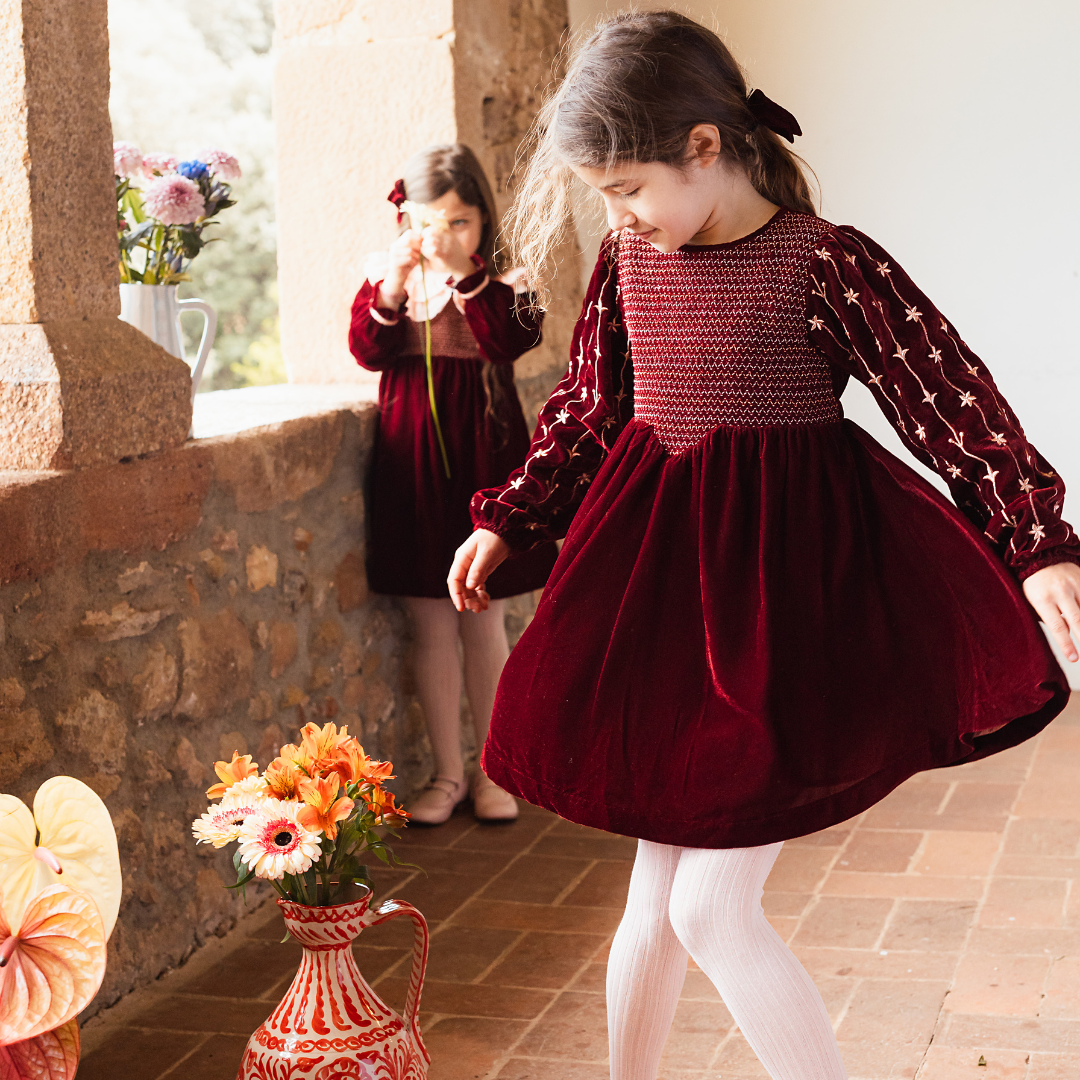 sold at Bombon shop, designed by Bachaa Paris, Dress, Velvet in Burgundy color, Plain lining in organic cotton voile, Fully hand embroidered sleeves with a golden thread, Smocked front, Gathered at the front and back, Golden buttons at the back. model view