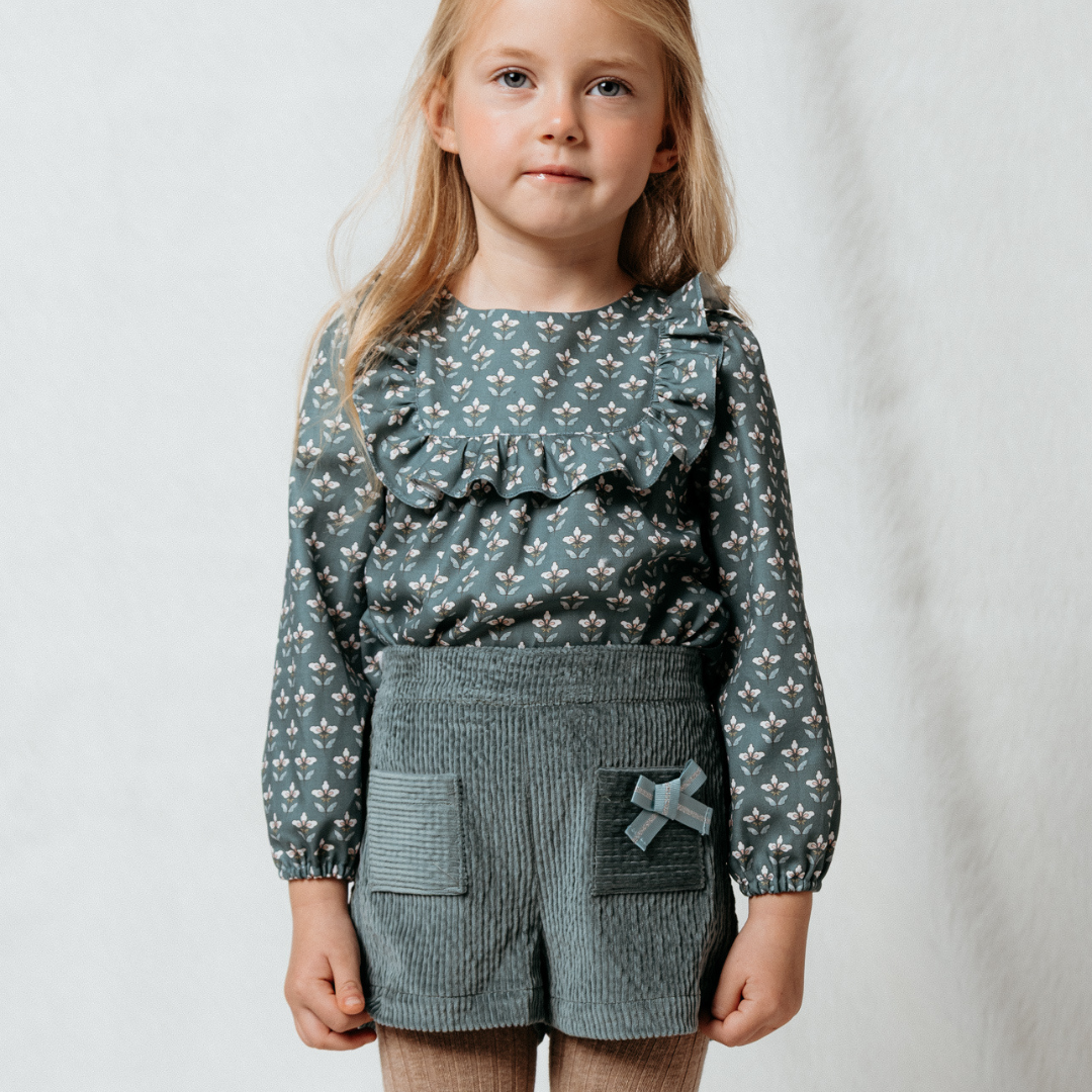Sold at Bombon shop, designed by Fina Ejerique, green corduroy shorts with back pockets and bow detail, pairs perfectly with the green floral viyella blouse. model