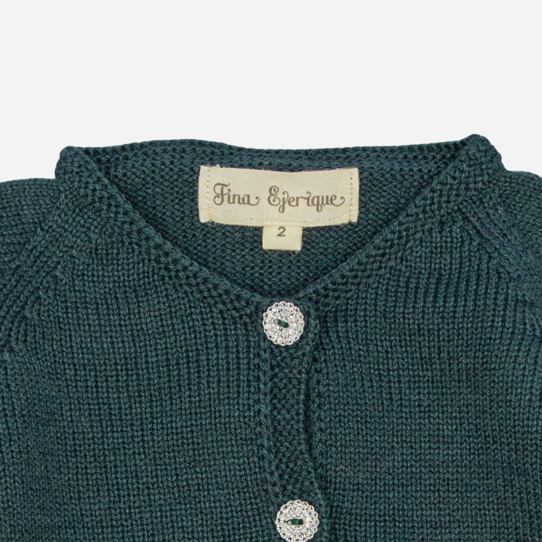 Sold at Bombon shop, designed by Fina Ejerique, a forest-green knit baby cardigan with scalloped trim and front buttons. zoom