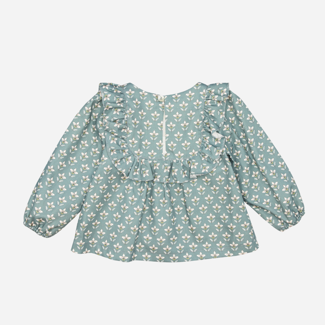 Sold at Bombon shop, designed by Fina Ejerique, a green floral viyella baby blouse with ruffled yoke and long sleeves, styled to pair with green corduroy shorts. back