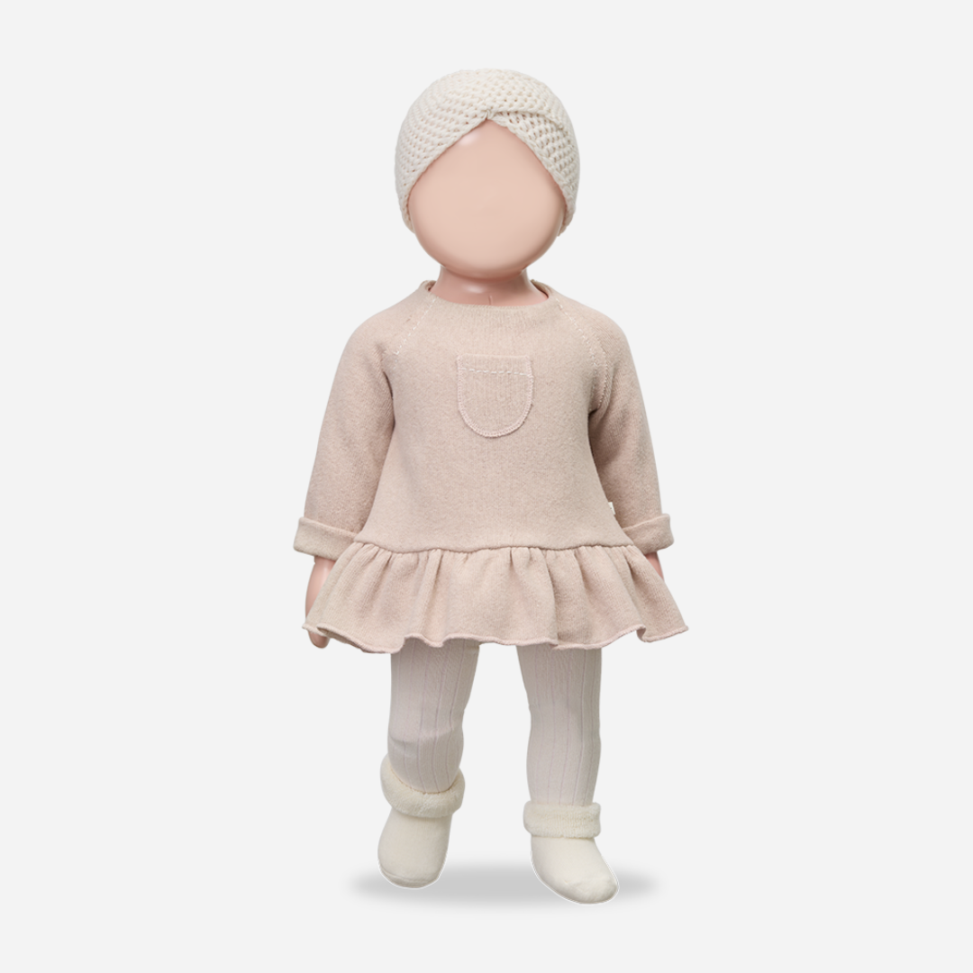 Baby doll wearing a beige outfit with a matching turban on a white background