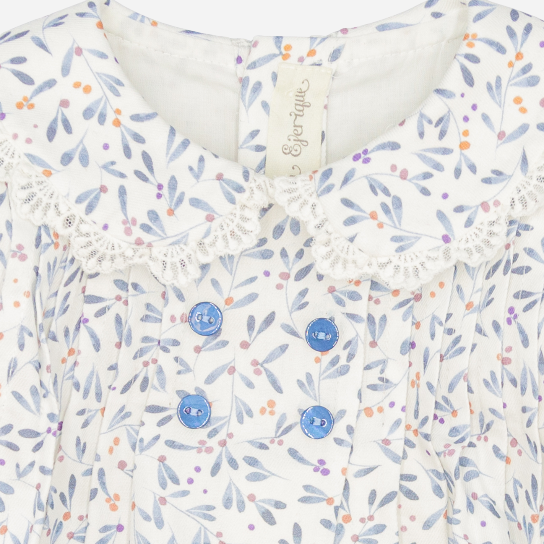 Sold at Bombon shop, designed by Fina Ejerique, a white baby dress with blue, lilac, and peach leaf print, lace-trim collar, blue buttons, and long sleeves. zoom