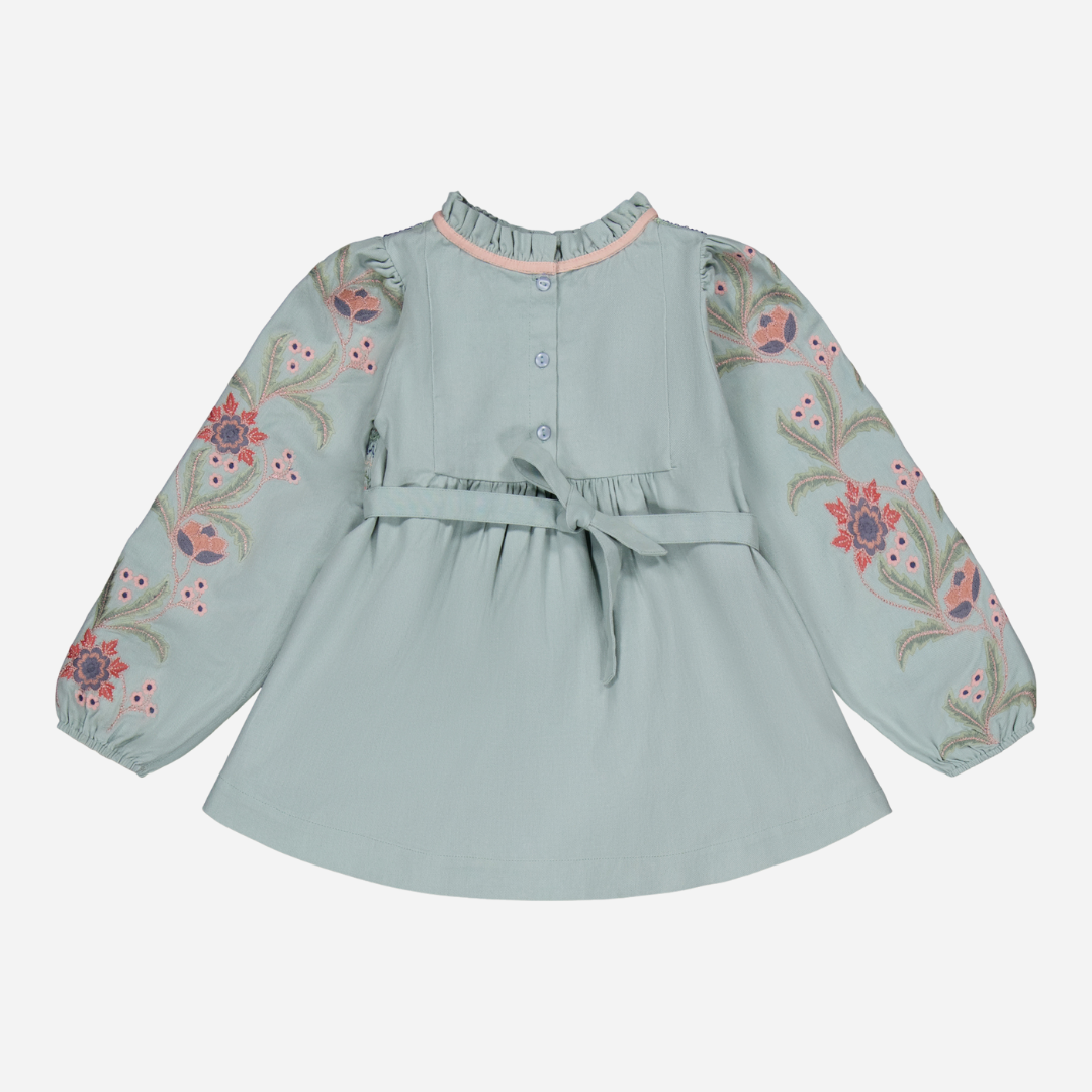 sold at Bombon shop, designed by Bachaa, Blouse/Short dress, Blue color, Organic cotton twill (167 g/m²), Plain lining in organic cotton voile, Long embroidered and elasticated sleeves, Smocked chest, Ruffled collar, Tone-on-tone buttons and belt at the back. Back view