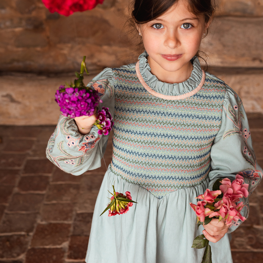 sold at Bombon shop, designed by Bachaa, Blouse/Short dress, Blue color, Organic cotton twill (167 g/m²), Plain lining in organic cotton voile, Long embroidered and elasticated sleeves, Smocked chest, Ruffled collar, Tone-on-tone buttons and belt at the back. Model view