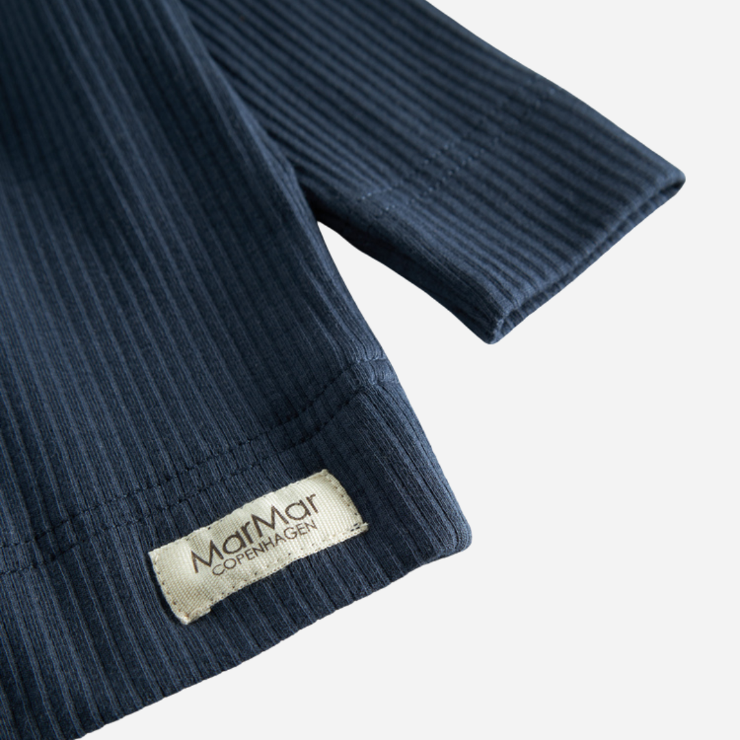 Sold at Bombon shop, designed by MarMar Copenhagen — navy ribbed organic cotton long-sleeve baby top with buttoned neckline, part of a matching set.