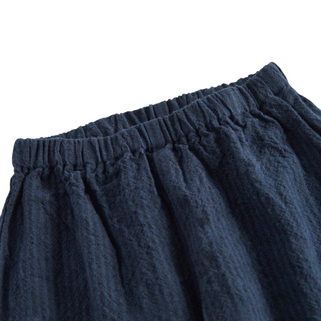 Sold at Bombon shop, designed by MarMar Copenhagen — navy 100% cotton textured baby pants with elastic waistband, part of a matching set.