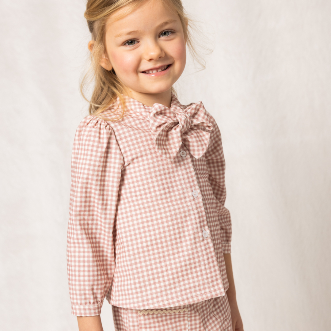 Sold at Bombon shop, designed by Fina Ejerique, pink gingham corduroy blouse with bow collar and puffed shoulders, styled to pair with the matching pants. model
