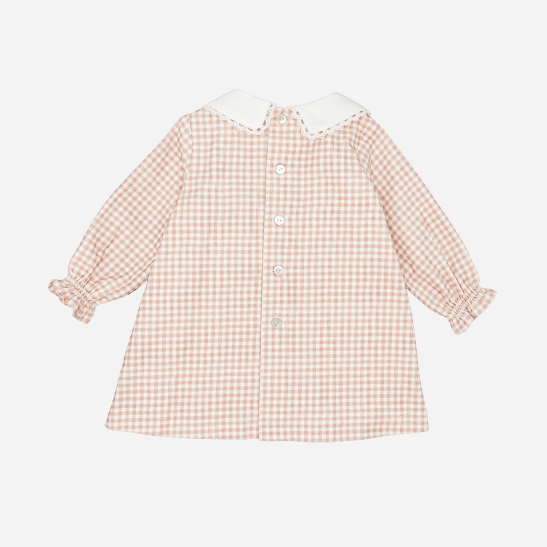 Sold at Bombon shop, designed by Fina Ejerique, a blush-pink gingham baby dress with white collar, lace trim, front pockets, and long sleeves. back
