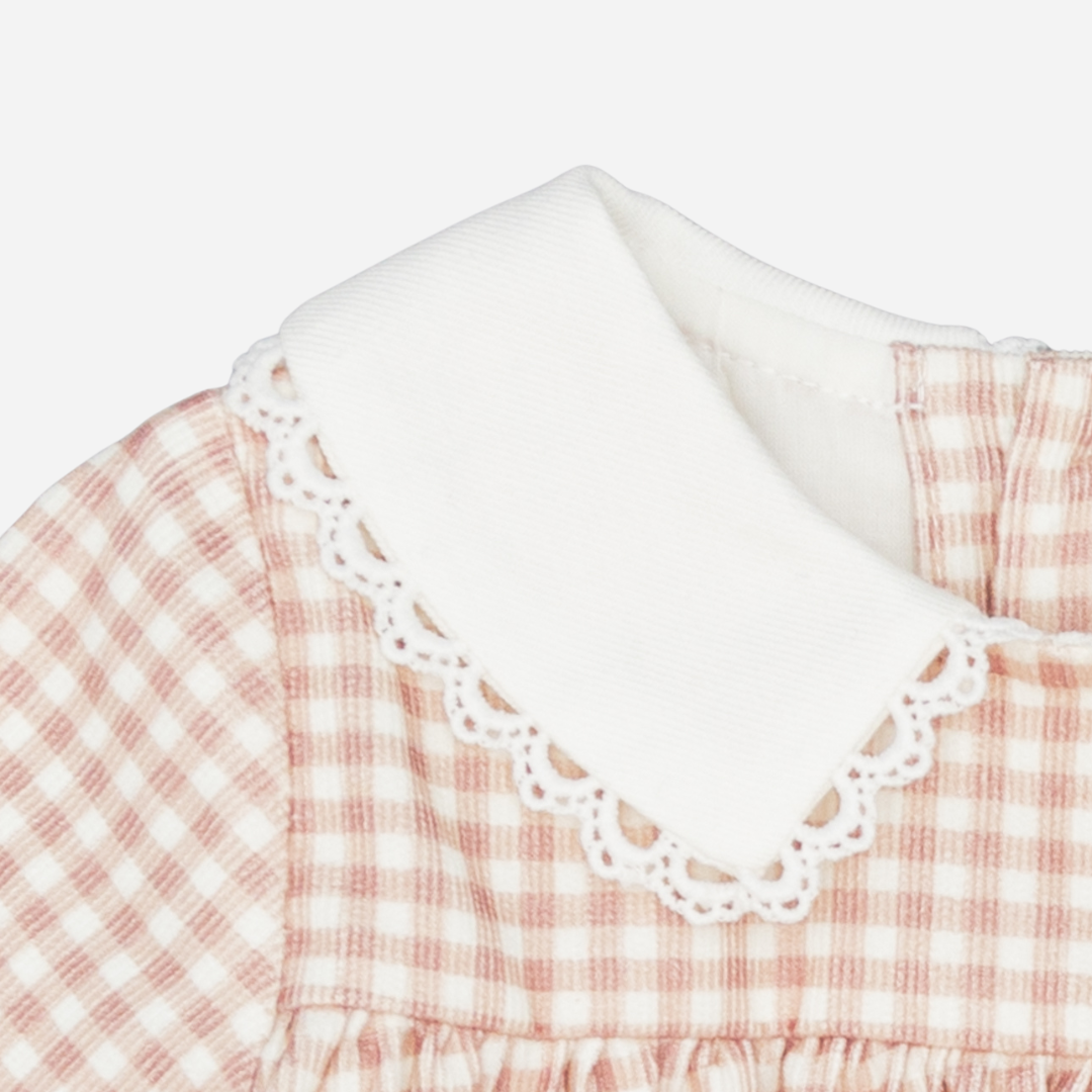 Sold at Bombon shop, designed by Fina Ejerique, a blush-pink gingham baby dress with white collar, lace trim, front pockets, and long sleeves. zoom