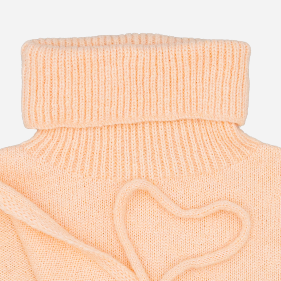 Sold at Bombon shop, designed by Fina Ejerique, pink knit vest with turtleneck and side ties, pairs perfectly with the floral blouse and beige textured skirt. zoom