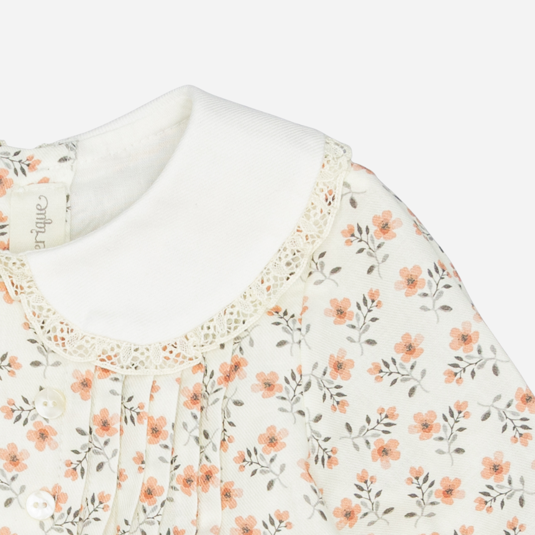 Sold at Bombon shop, designed by Fina Ejerique, a white viyella baby dress with pink and green floral print, Peter Pan collar with lace trim, pleated front, and long sleeves. zoom