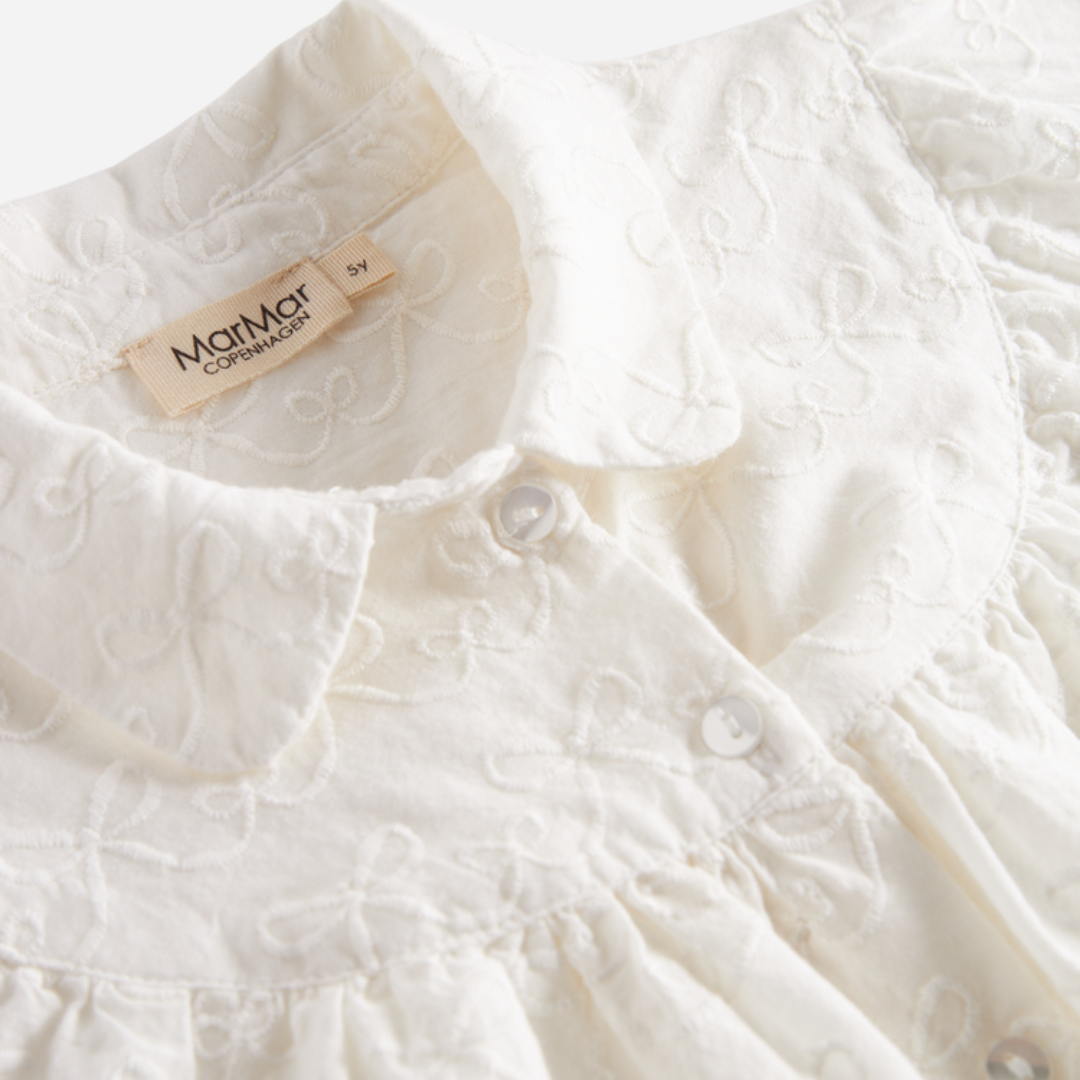 Sold at Bombon shop, designed by MarMar Copenhagen — cream 100% cotton baby blouse with rounded collar and gathered details, pairs perfectly with the navy pinafore dress.