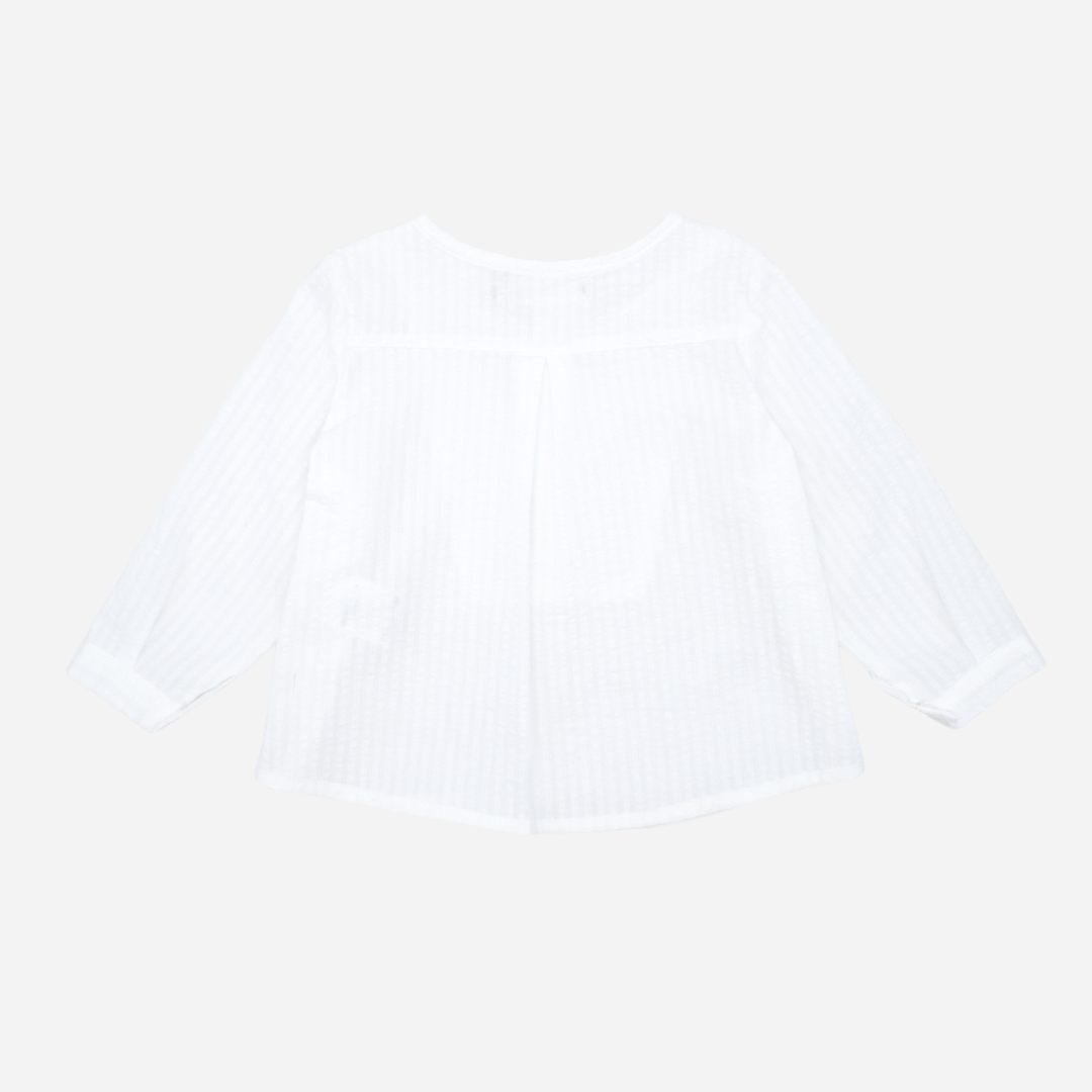 Sold at Bombon shop, designed by Fina Ejerique brand, white long sleeve bib shirt for babies and toddlers is perfect for spring and summer. Back view