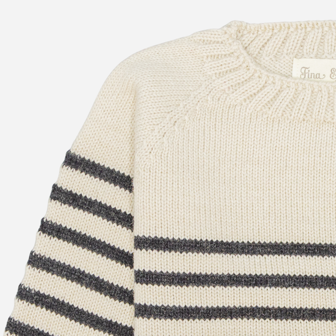 Sold at Bombon shop, designed by Fina Ejerique, a cream knit baby sweater with gray horizontal stripes, styled to pair with grey twill trousers. zoom