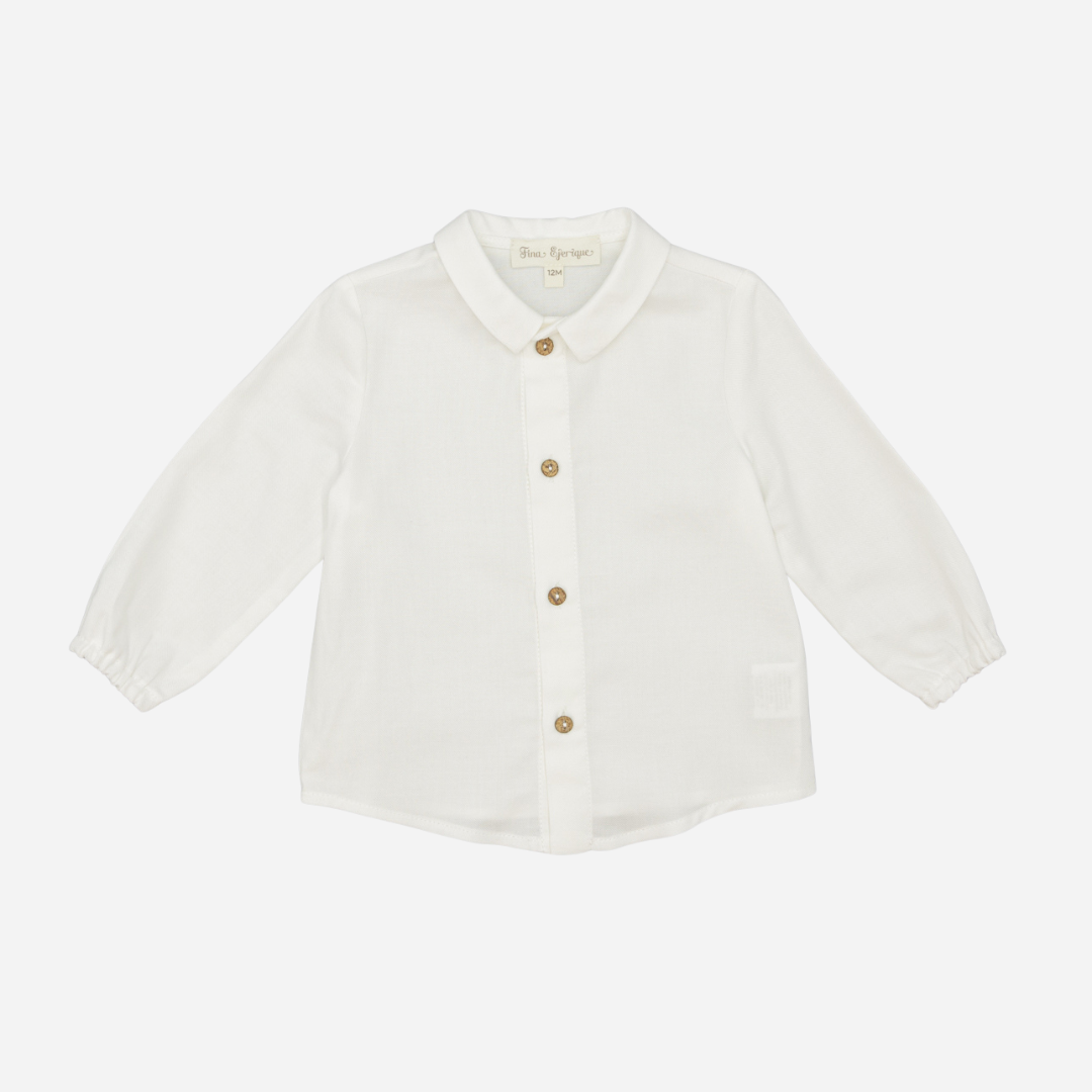 Sold at Bombon shop, designed by Fina Ejerique, a white viyella baby shirt with rounded collar, wooden buttons, and long sleeves. front