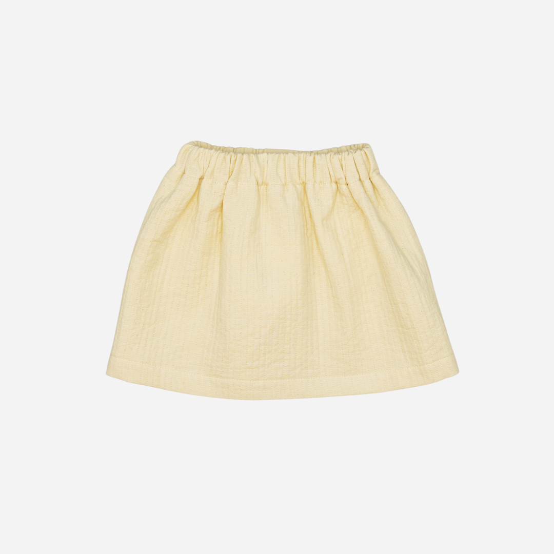 Sold at Bombon shop, designed by Fina Ejerique, beige textured skirt with button front and scalloped pockets, pairs perfectly with the floral blouse and pink vest. back