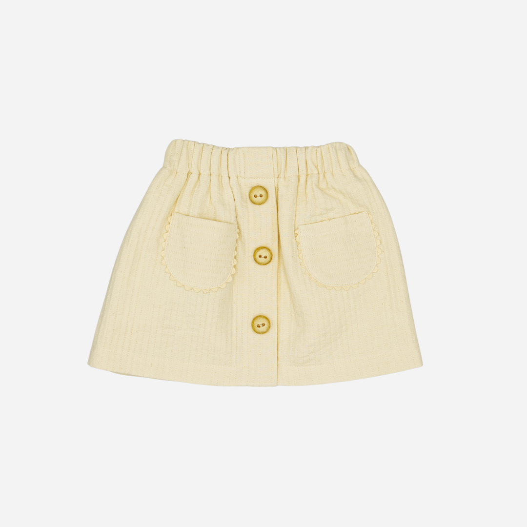 Sold at Bombon shop, designed by Fina Ejerique, beige textured skirt with button front and scalloped pockets, pairs perfectly with the floral blouse and pink vest. front