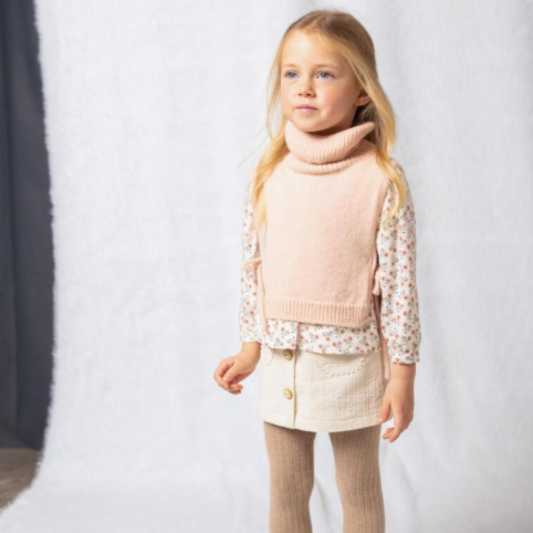 Sold at Bombon shop, designed by Fina Ejerique, beige textured skirt with button front and scalloped pockets, pairs perfectly with the floral blouse and pink vest. model