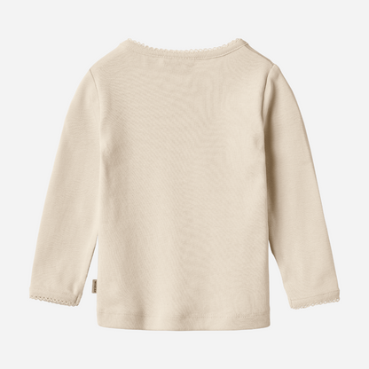 Sold at Bombon shop, designed by Wheat, this eggshell-colored ribbed long-sleeve tee features picot edging and a snap closure at the shoulder. back