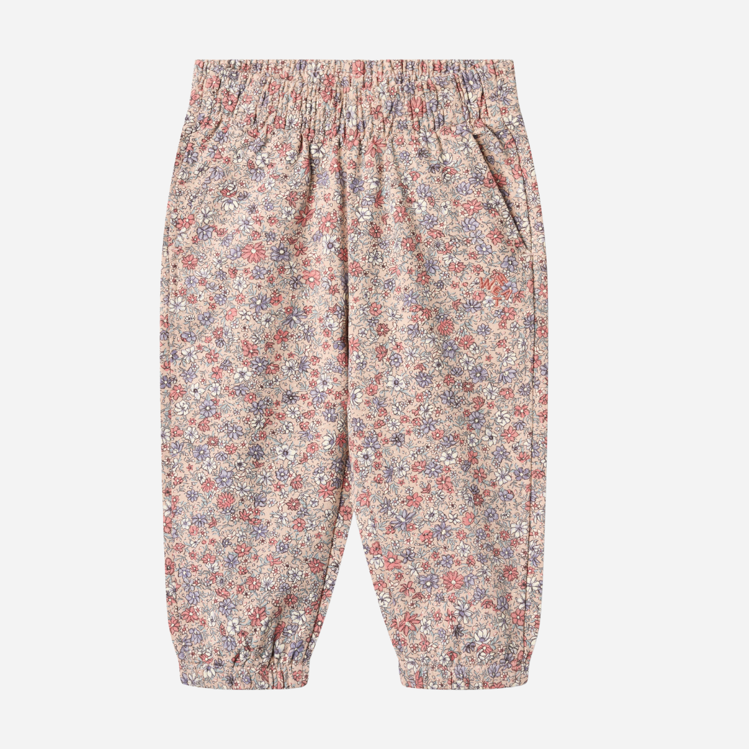 Sold at Bombon shop, designed by Wheat, these floral print pants feature an elastic waist and cuffs in soft rose and lavender tones. front