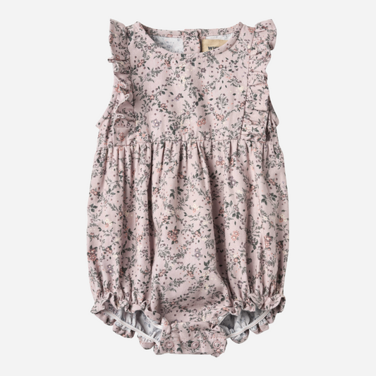 Sold at Bombon shop, designed by Wheat — sleeveless lilac floral baby romper with ruffled shoulders, gathered waist, and elasticized leg openings with snap closures for easy changing. front