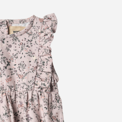 Sold at Bombon shop, designed by Wheat — sleeveless lilac floral baby romper with ruffled shoulders, gathered waist, and elasticized leg openings with snap closures for easy changing. top