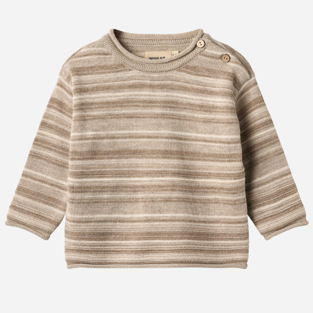 Sold at Bombon shop, designed by Wheat — knit baby sweater in warm sand stripe with shoulder buttons and soft texture. front