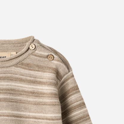 Sold at Bombon shop, designed by Wheat — knit baby sweater in warm sand stripe with shoulder buttons and soft texture. top