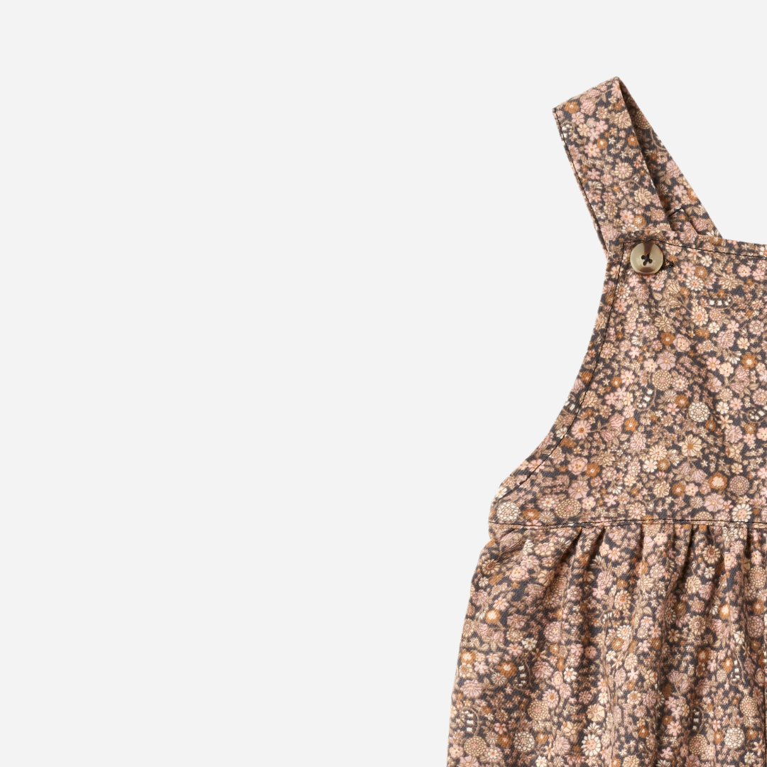 Sold at Bombon shop, designed by Wheat, this baby overall features an allover black sea garden floral print with adjustable button straps and snap closures along the inseam. top