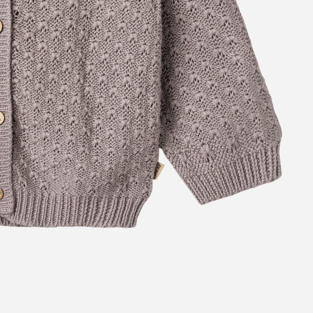 Sold at Bombon shop, designed by Wheat, this dusty purple pointelle cardigan features wooden buttons and a cozy knit texture. bottom