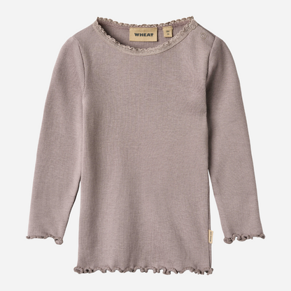Sold at Bombon shop, designed by Wheat, this dusty purple ribbed long-sleeve tee features ruffle edges and a soft, stretchy finish. front