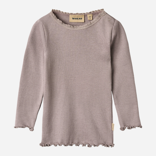 Sold at Bombon shop, designed by Wheat, this dusty purple ribbed long-sleeve tee features ruffle edges and a soft, stretchy finish. front