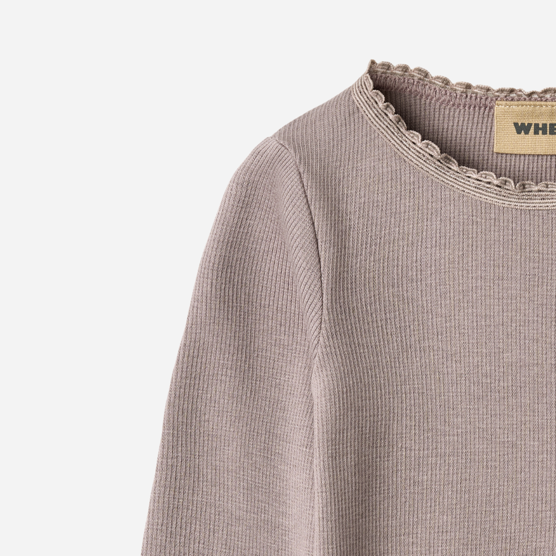 Sold at Bombon shop, designed by Wheat, this dusty purple ribbed long-sleeve tee features ruffle edges and a soft, stretchy finish. top