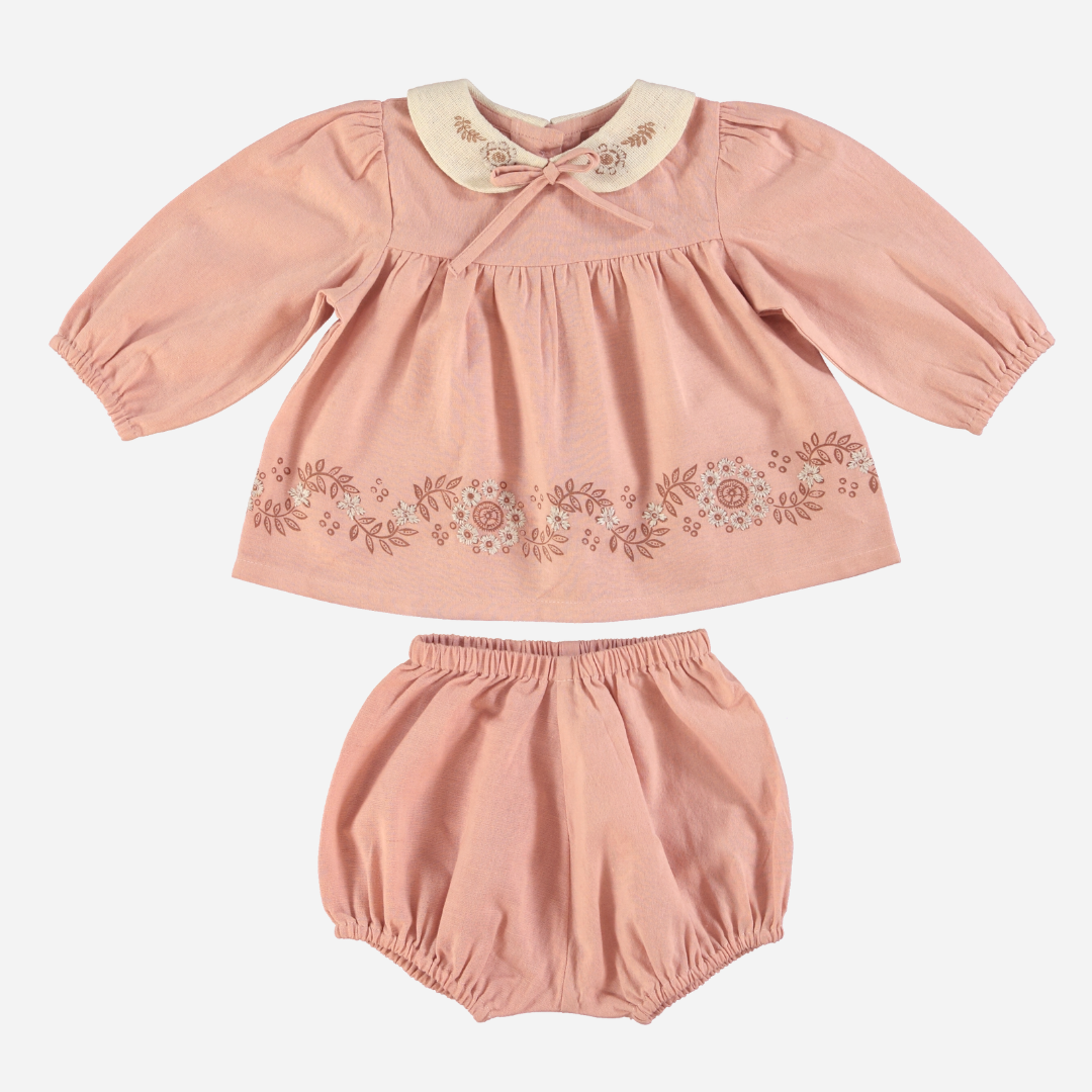 Sold at Bombon Shop, this Bebe Organic baby girl outfit features a soft pink organic cotton blouse with floral embroidery, a contrasting Peter Pan collar with delicate stitching, and gently puffed sleeves, paired with matching bloomers — a sweet and timeless set perfect for everyday wear or special occasions.