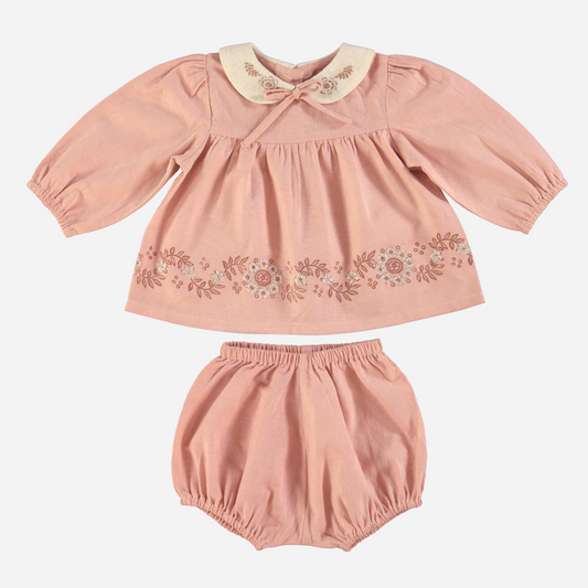 Sold at Bombon Shop, this Bebe Organic baby girl outfit features a soft pink organic cotton blouse with floral embroidery, a contrasting Peter Pan collar with delicate stitching, and gently puffed sleeves, paired with matching bloomers — a sweet and timeless set perfect for everyday wear or special occasions.