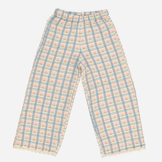 Sold at Bombon Shop, these Bebe Organic baby and toddler girl pants feature a pastel plaid print in blue, pink, and cream, crafted from soft organic cotton with a comfortable elastic waistband and scalloped trim at the hem — pair with the matching top for a complete vintage-inspired look