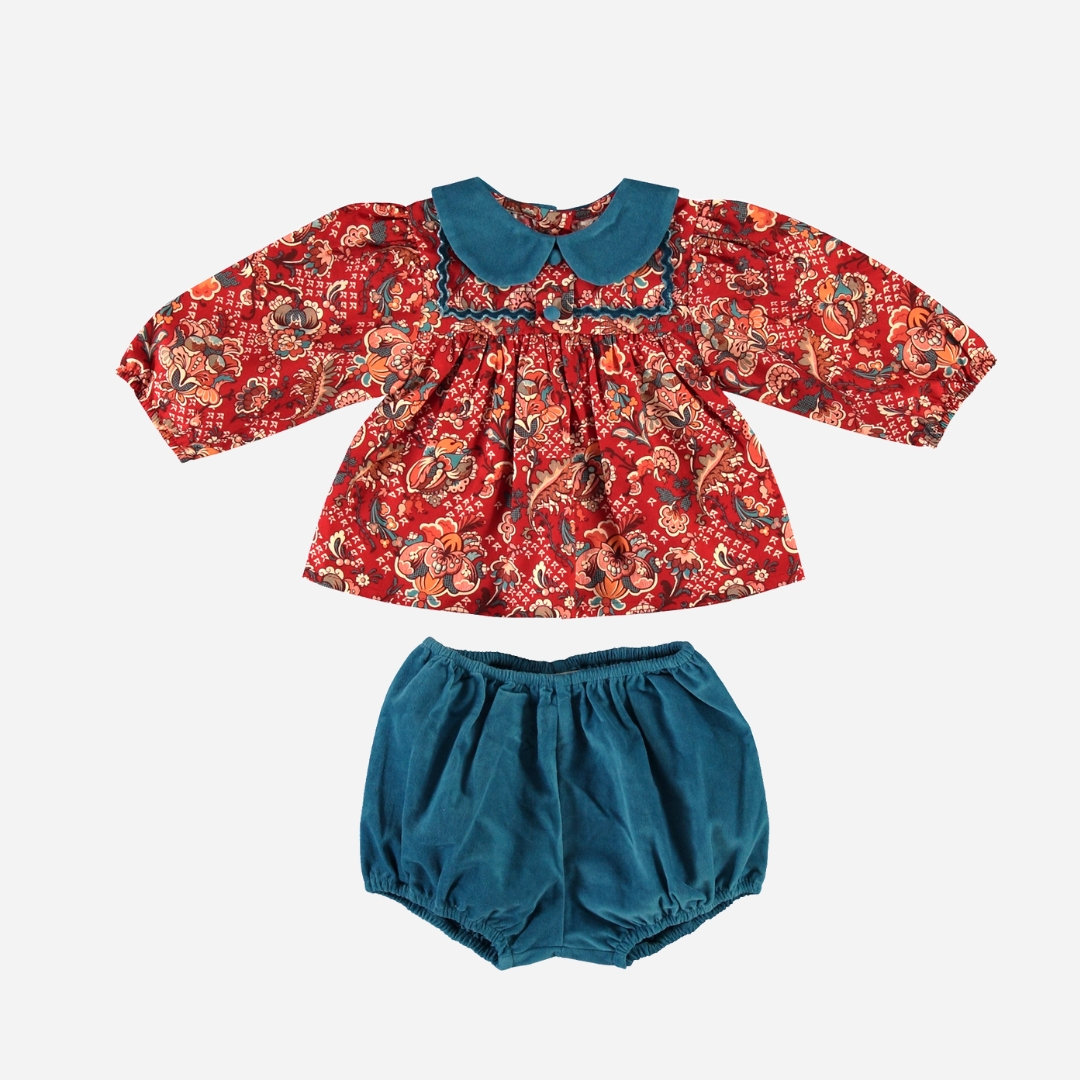 Sold at Bombon Shop, this Bebe Organic baby girl outfit features a floral print top in rich red tones with a contrasting teal Peter Pan collar and long sleeves, paired with coordinating teal corduroy bloomers — a beautifully crafted, vintage-inspired set made from soft organic cotton, perfect for fall and winter wardrobes.