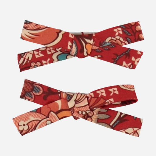 Sold at Bombon Shop, this Bebe Organic set of two baby girl hair clips features vibrant red floral fabric bows made from soft organic cotton — a bold and beautiful accessory to elevate any outfit with a playful vintage touch.