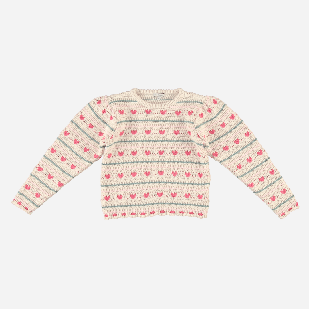 Sold at Bombon Shop, this Bebe Organic girls’ knit sweater is made from soft organic cotton and features an allover pattern of pink hearts and soft blue stripes on a natural cream base — a cozy and playful cold-weather essential with a vintage feel, perfect for layering in fall and winter.