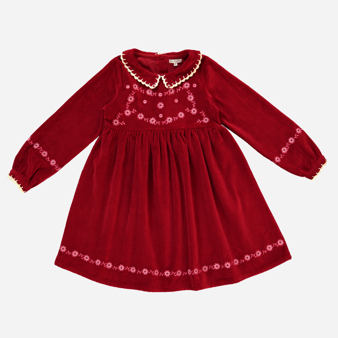 Sold at Bombon Shop, this Bebe Organic velvet dress for baby and toddler girls features a rich red hue, delicate floral embroidery, a scalloped ivory collar, and long sleeves — a timeless holiday dress perfect for festive gatherings and special moments.