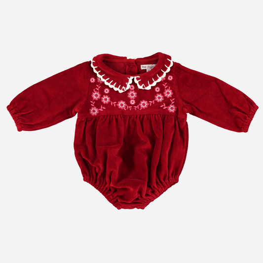 Sold at Bombon Shop, this Bebe Organic baby girl romper is crafted from rich red velvet with delicate floral embroidery, a scalloped ivory collar, and long sleeves — a festive and elegant one-piece perfect for holiday gatherings and special occasions.