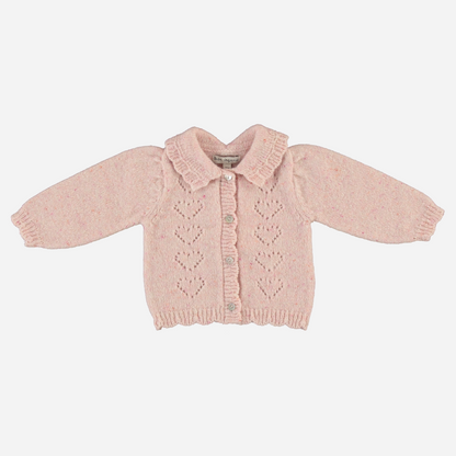 Sold at Bombon Shop, this Bebe Organic baby and toddler girl cardigan is crafted from soft pink wool with delicate heart-shaped knit details, ruffled collar, and front button closure — pair it with the matching knit pants for a cozy, coordinated look perfect for fall and winter layering.