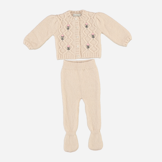 Sold at Bombon Shop, this Bebe Organic baby knit set includes a cream-colored cardigan with delicate floral embroidery and cable knit detailing, paired with matching footed pants — both crafted from soft organic wool for a cozy, heirloom-quality outfit perfect for fall and winter.
