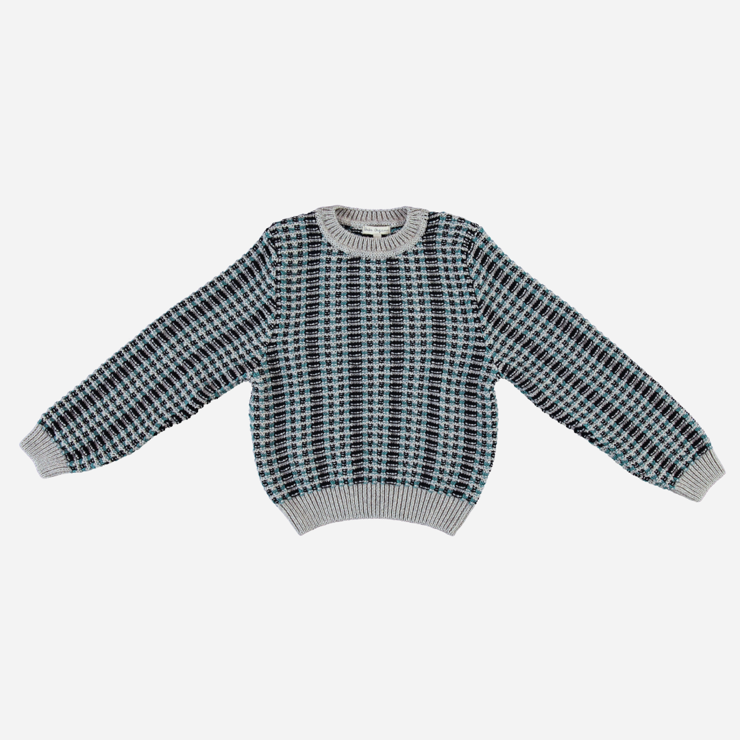 Sold at Bombon Shop, this Bebe Organic kids’ sweater is crafted from cozy organic wool in a stylish jacquard knit pattern featuring shades of grey, teal, and navy — a warm and timeless cold-weather essential perfect for baby and toddler boys