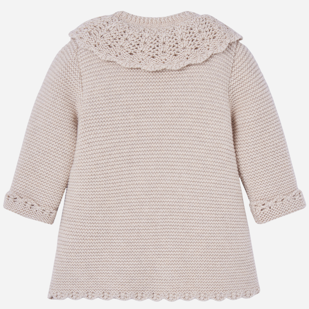 Sold at Bombon shop, designed by Paz Rodriguez. Beige knit coat with openwork scalloped collar and pearlescent buttons down the front.